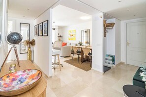 A modern living room with a dining area, a large mirror, and a globe on a tripod stand. - BV373A - Corner penthouse with rooftop terrace (Calahonda)