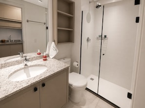 A modern bathroom with a granite countertop sink, a toilet, and a glass-enclosed shower. - SETIN 1508 (São Paulo)
