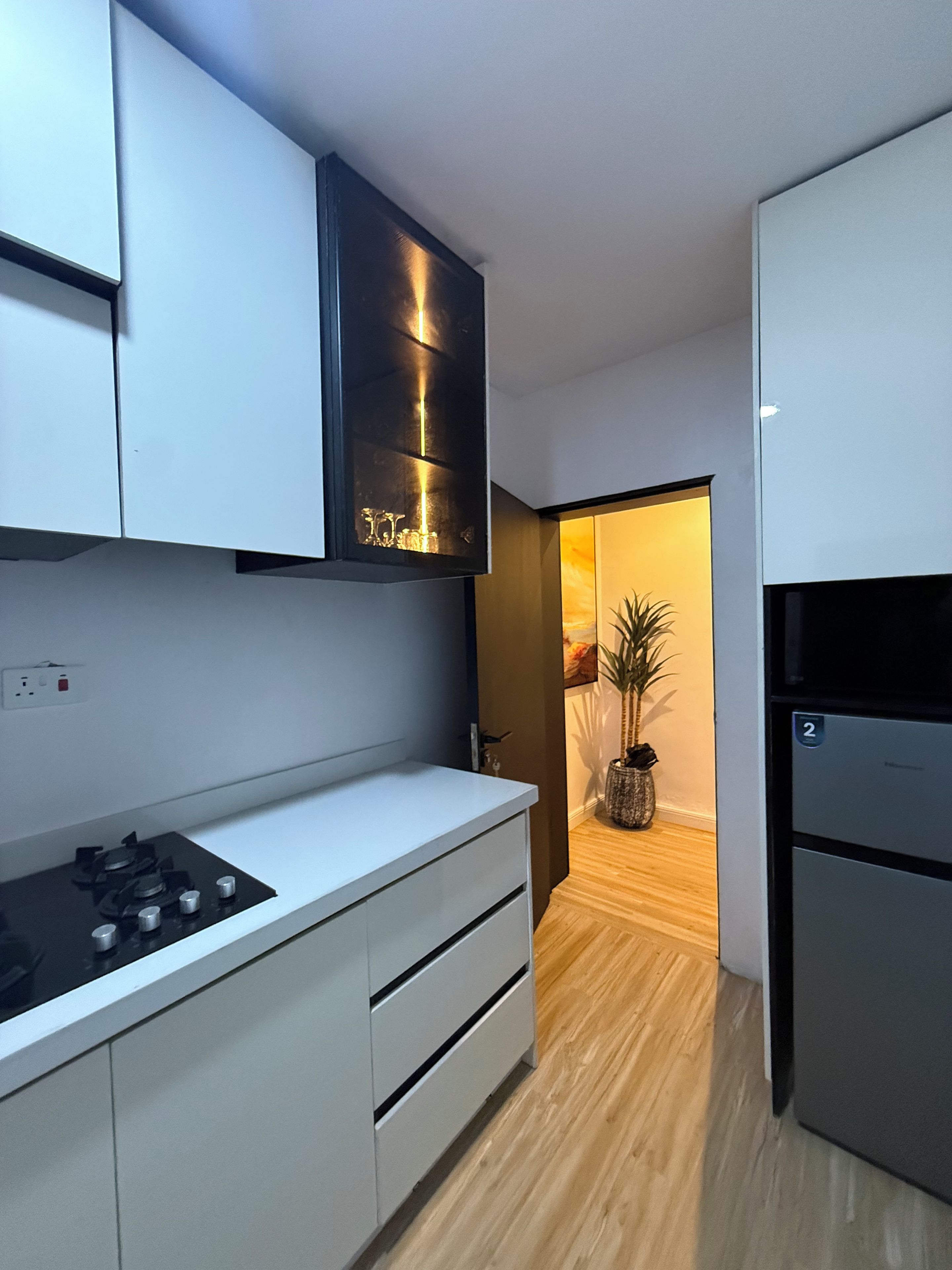 Eine moderne Küche mit weißen Schränken, einem Edelstahlkühlschrank und einem eingebauten Backofen.