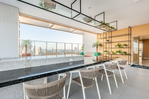 A modern interior with a balcony, seating area, and city views. - Rooftop Agamenon #408 City View by Carpediem (Recife)