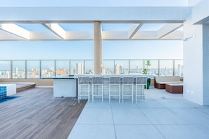 A rooftop terrace with a city view, seating area, and a bar. - Rooftop Agamenon #408 City View by Carpediem (Recife)