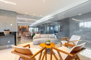 A modern interior with a sofa, chairs, a coffee table, and a glass partition. - Rooftop Agamenon #408 City View by Carpediem (Recife)