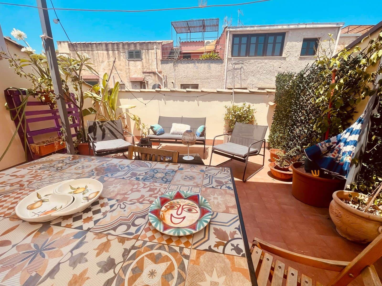 Eine Terrasse im Freien mit einem Tisch, Stühlen und einem dekorativen Teller.