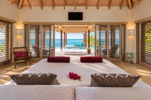Un dormitorio con una cama grande, dos toallas rojas y un centro de mesa con flores.