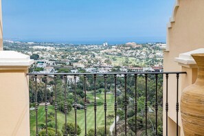 Ein Balkon mit Blick auf ein Wohngebiet, einen Golfplatz und den Ozean.