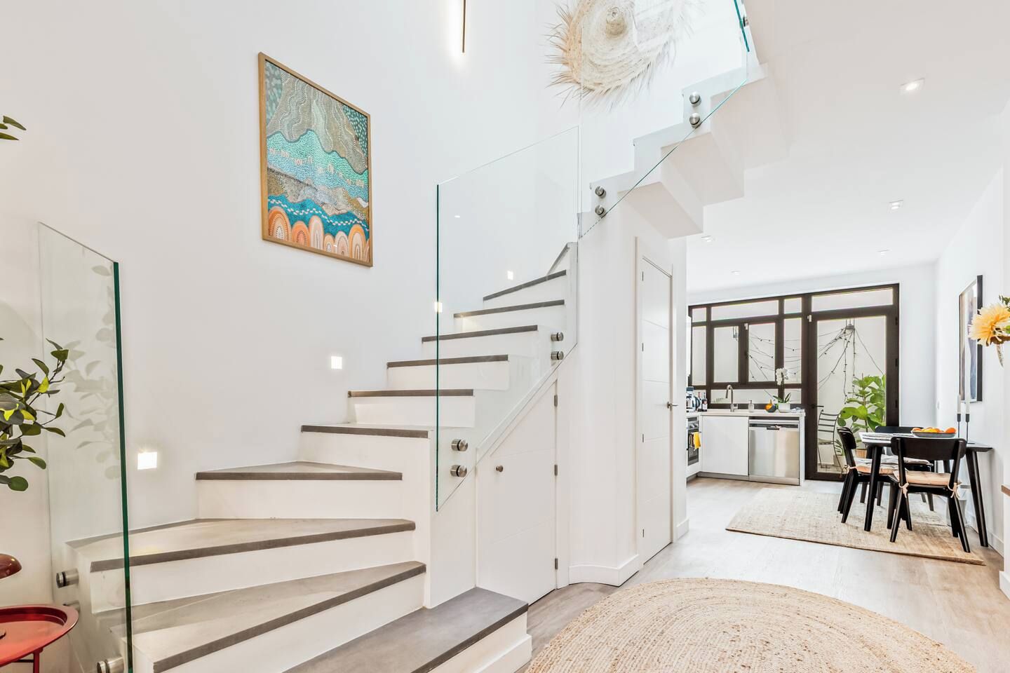Ein modernes Interieur mit Treppe, Essbereich und Küche.