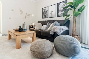 Ein Wohnzimmer mit einer Couch, einem Couchtisch und zwei runden Hocker.