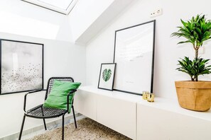 A modern interior with a seating area, framed artwork, a potted plant, and a window providing natural light. - ELD2-Luxury 3 Bedroom Penthouse in Nueva Andalucia (Marbella)