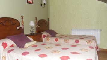 Un dormitorio con dos camas, una mesita de noche, una lámpara y un radiador.