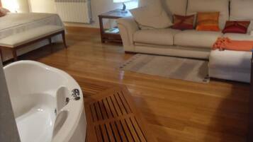 A room with a bed, a sofa, a lamp, and a radiator.