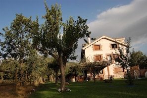 Un edificio de dos pisos con un jardín delantero.