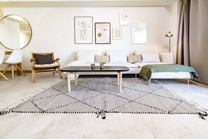 A modern living room with a sofa, a coffee table, and a chair. There are framed artworks on the wall. - INf12A- Apartment close to beach and old town (Estepona)