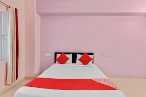 A single bed with a white and red bedspread, two red pillows, and a red accent pillow on a headboard. - Hotel O Aaira Inn (Bangalore)