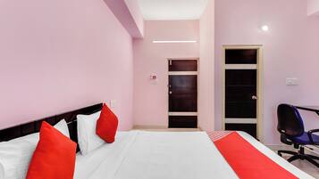 Een hotelkamer met een bed, een bureau en een stoel.
