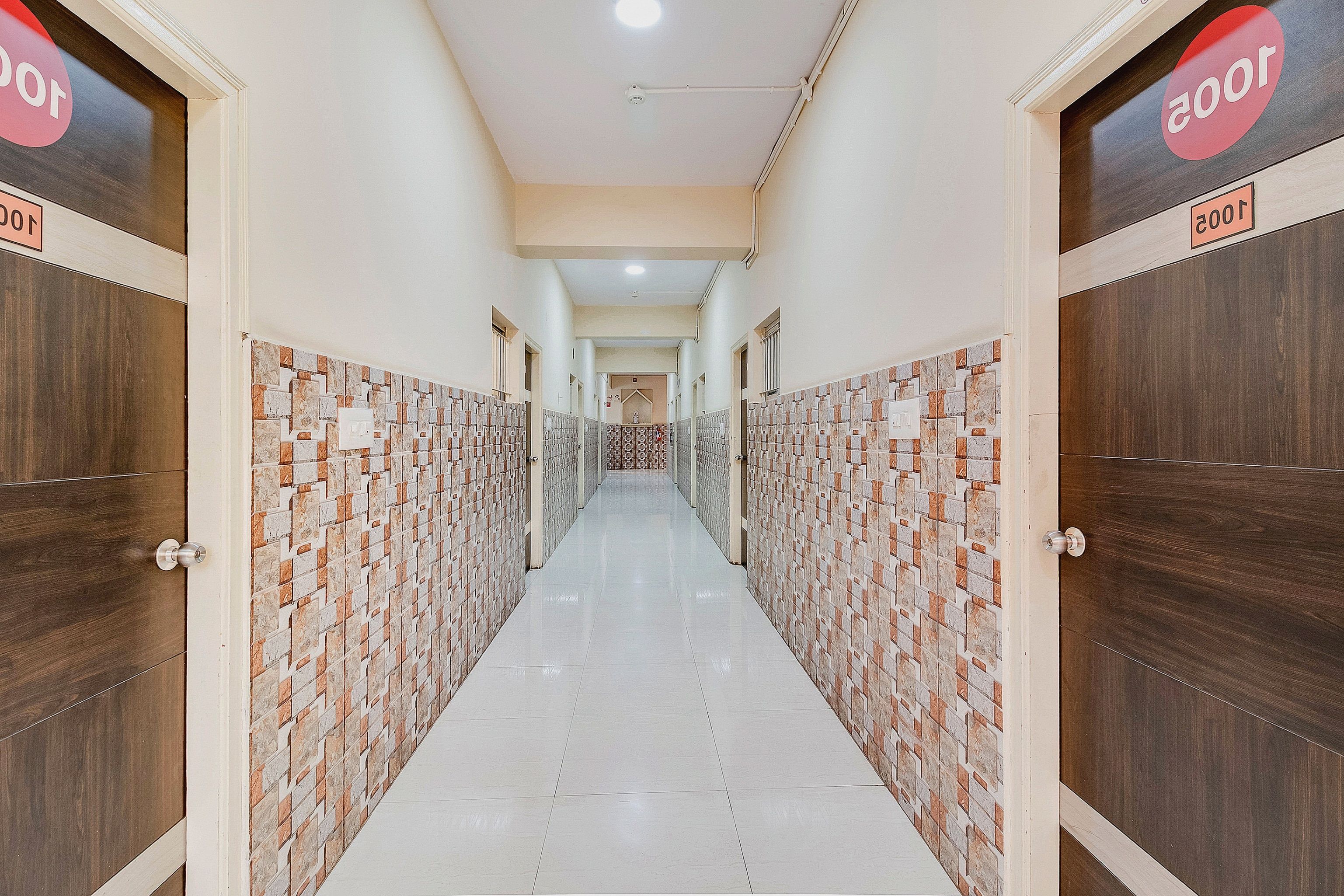 Un pasillo con casilleros a ambos lados, que conduce a una puerta al final.