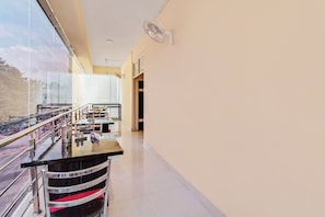 A modern hotel lobby with a glass railing, a reception desk, and a clear view of the outdoors.