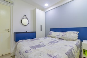 Quarto com cama, guarda-roupa, espelho e mesa de cabeceira.
