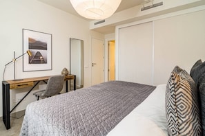 A bedroom with a bed, a desk, a chair, a mirror, and a door. - IN33K- Stunning city apartment close to beaches (Estepona)