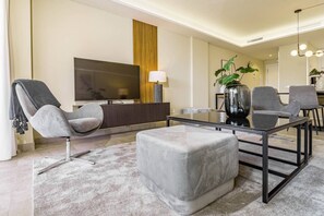 A modern living room with a sofa, armchair, ottoman, and a glass coffee table. - IN33K- Stunning city apartment close to beaches (Estepona)