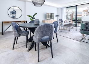 A modern dining area with a round table and four grey upholstered chairs. - INf32L- Modern city apartment, families only (Estepona)