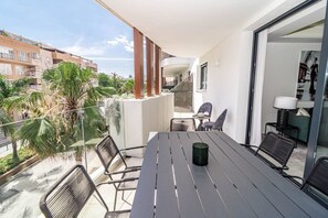 A balcony with a table and chairs, a view of the city, and a building with balconies. - INf32L- Modern city apartment, families only (Estepona)