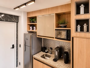 Eine moderne Küche mit einem Edelstahl-Kühlschrank, einer Kaffeemaschine und einer Mikrowelle.