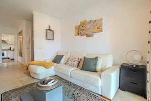 A modern living room with a white sofa, a coffee table, and a zebra-patterned rug. - LAlq13 Stunning Frontline Golf 3 bed apt (Benahavís)