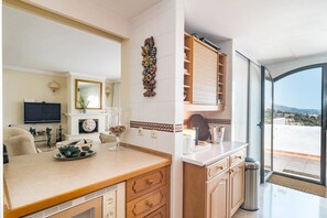 A modern kitchen with a dining area, a TV, and a view of the landscape. - LAG - Spacious townhouse with private jacuzzi (Benahavis)