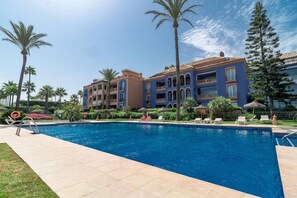A hotel with a swimming pool, palm trees, and a clear sky. - LAP- 3 bed apartment on the beach. Families only (Bahía de Casares)