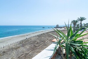 A coastal view with a sandy beach, a clear blue sea, and a stone structure in the distance. - LAP- 3 bed apartment on the beach. Families only (Bahía de Casares)