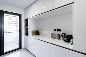 A modern kitchen with white cabinets, a toaster, a kettle, and a knife block. - Luxury Resort Apt with Sea View & Pools - LAE23i (Estepona)
