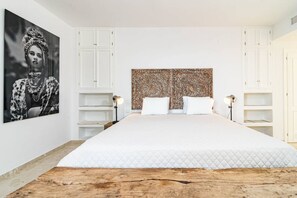 A bedroom with a large bed, white cabinetry, a decorative headboard, and a framed artwork on the wall. - JDG7-Stunning holiday home 100 meters from beach (Marbella)