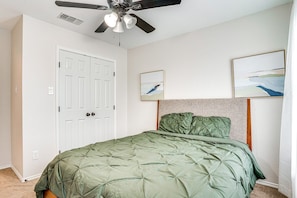 A bedroom with a bed, a ceiling fan, a white door, and two framed artworks on the wall. - Spacious 5-bedroom Luxury Villa with Pool, Parking in peaceful Burleson (Burleson)