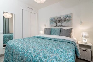 A bedroom with a bed, a nightstand, a lamp, a painting, and a wardrobe. - INf46P - Spacious holiday home in Estepona (Estepona)