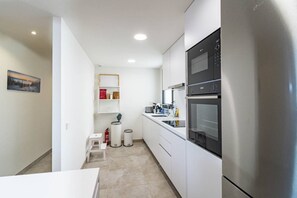 A compact kitchen with white cabinets, a stainless steel refrigerator, and a built-in oven. - INf46P - Spacious holiday home in Estepona (Estepona)
