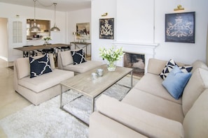 Ein modernes Wohnzimmer mit einer Sofagarnitur, einem Couchtisch und einem Kamin.