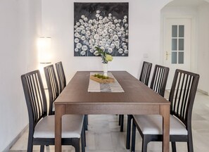 A dining room with a rectangular table, six chairs, and a painting above the table. - LCR4 - Large 3-Bedroom Apartment Near Beach (Marbella)