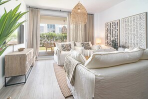 A modern bedroom with a large bed, a seating area with a sofa and chairs, a dining table, and a view of the outdoors. - LM10bb- Modern Living with Large sunny terrace (Estepona)