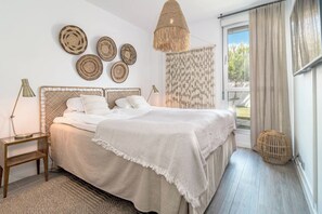 A bedroom with a bed, bedside tables, a hanging light fixture, and wall decor. - LM10bb- Modern Living with Large sunny terrace (Estepona)