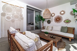 A modern living room with a sofa, wooden coffee table, and a bed with white bedding. - LM10bb- Modern Living with Large sunny terrace (Estepona)