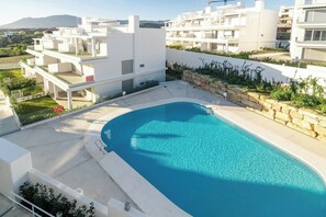 A modern residential building with a swimming pool, balconies, and a view of the surrounding landscape. - LM10bb- Modern Living with Large sunny terrace (Estepona)