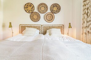 A bed with a woven headboard, two bedside lamps, and a patterned throw blanket. - LM10bb- Modern Living with Large sunny terrace (Estepona)