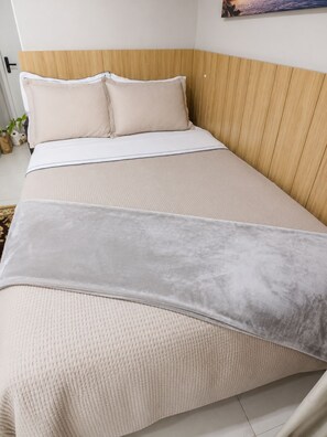 Ein Bett mit Kopfteil, zwei Kissen und einer Decke.
