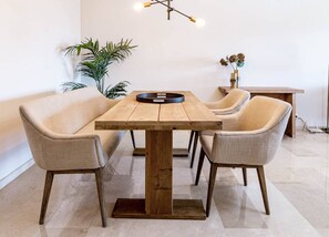 A dining area with a wooden table, four chairs, a hanging light fixture, and a potted plant. - MA7B-Stunning holiday home top location (Marbella)