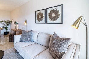 A modern living room with a sofa, two decorative wall art pieces, a floor lamp, and a side table with a plant. - MA7B-Stunning holiday home top location (Marbella)