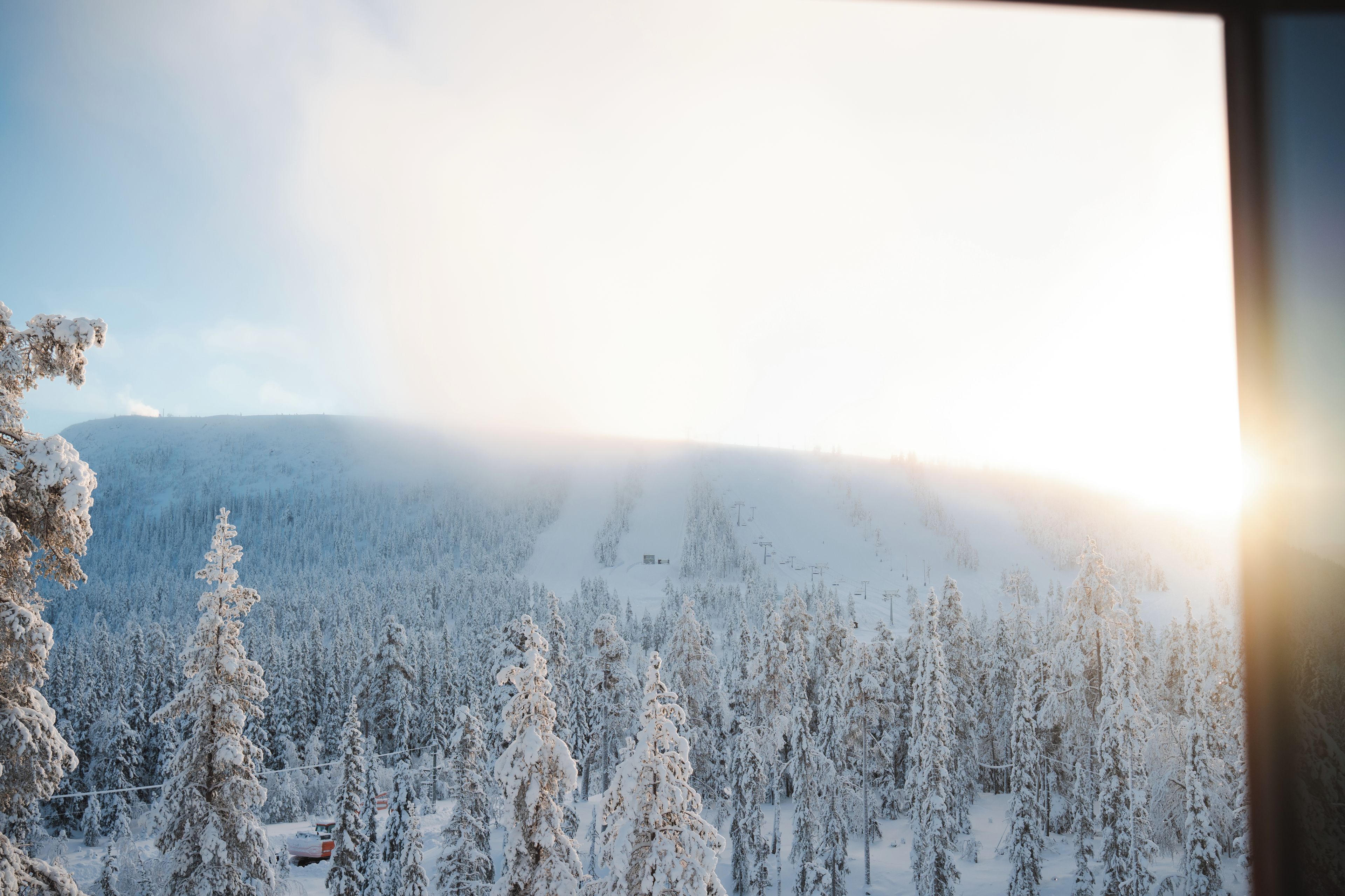 A snowy mountain landscape with a ski lift and a cabin.