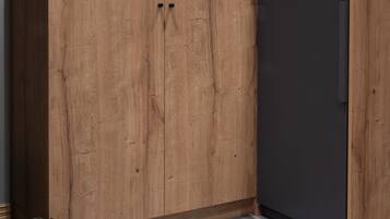 Una stanza con un ampio armadio in legno, un frigorifero scuro e un pavimento decorato.