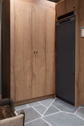 A room with a large wooden wardrobe, a dark-colored refrigerator, and a patterned floor. - Mountain Lodge Idrefjäll (Idre)