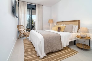 A bedroom with a bed, a chair, a bedside table with a lamp, and a view of the outdoors. - LMe4BB Sb4bb- apotel las mesas by roomservices (Estepona)