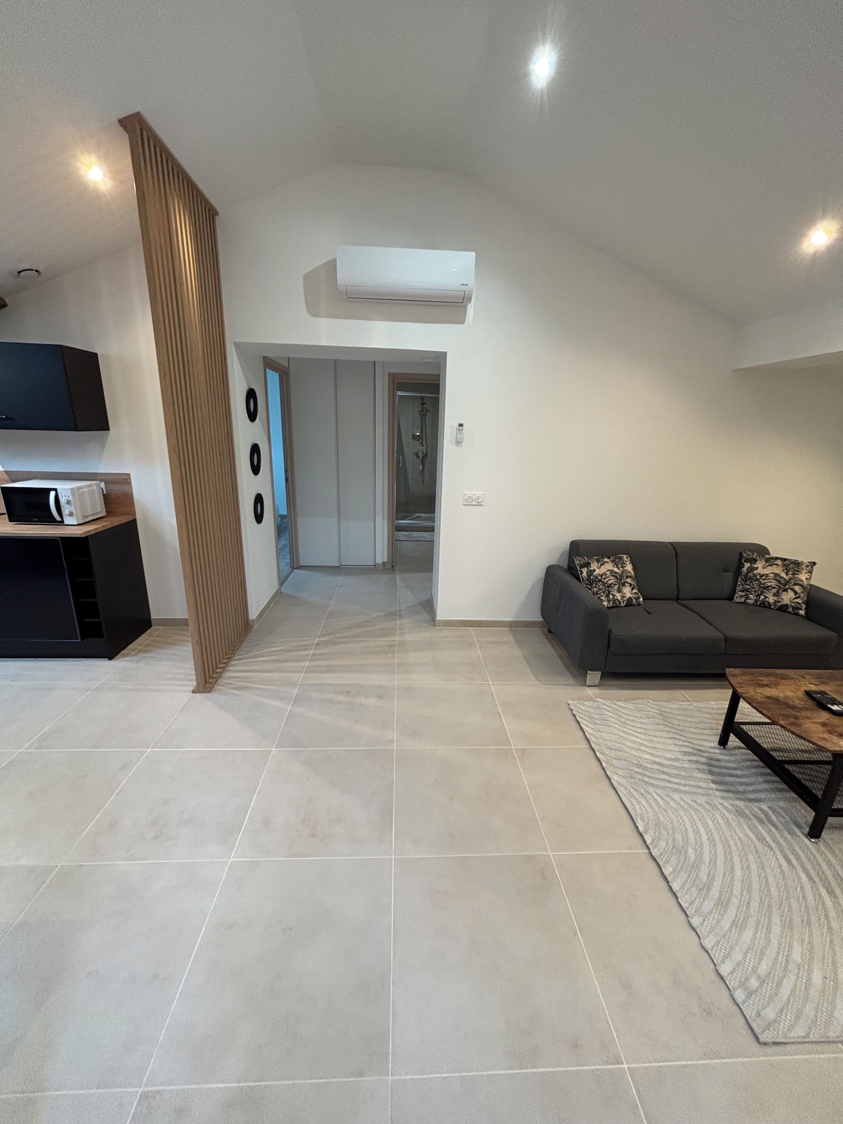 A modern living room with a sofa, a coffee table, and a flat-screen TV.